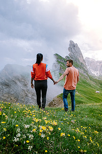 一对夫妇在 Italien Dolomites 度假远足，在 Seceda 峰上欣赏美景。