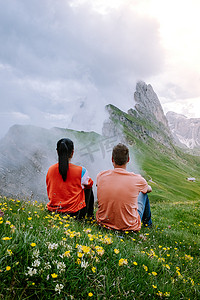 一对夫妇在 Italien Dolomites 度假远足，在 Seceda 峰上欣赏美景。