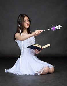 驱魔摄影照片_女孩-有书和魔杖的巫师