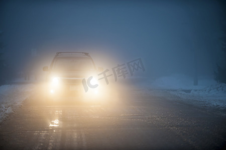 驾驶汽车摄影照片_汽车在雾中行驶的车灯