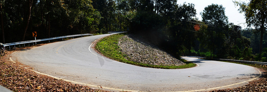 斜坡自行车摄影照片_自行车在斜坡上坡乡村沥青路上没有汽车，全景