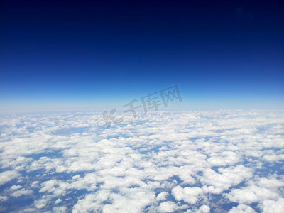 在清澈的蓝天背景下，从飞机上俯瞰白云