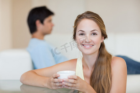 未婚夫坐在沙发上时喝茶的女人