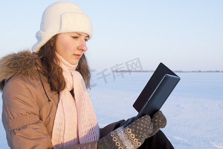 看电子书摄影照片_冬时在户外看电子书的少女