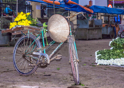 河内满载鲜花和圆锥形帽子的运输自行车