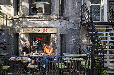 两个年轻人正在一家现代都市咖啡馆喝酒。