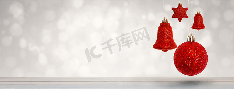 悬挂木板摄影照片_红色圣诞铃铛装饰悬挂的合成图像