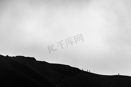 攀登在埃特纳火山火山口边缘的人的小剪影