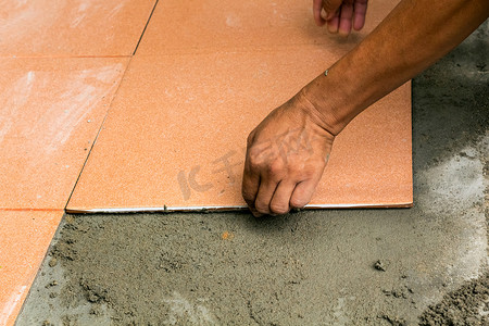 男建筑工人在家贴瓷砖，瓷砖地板粘合剂 r