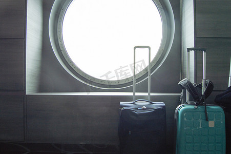 在船的圆形舷窗前旅行的两个手提箱，休闲或商务旅行的概念