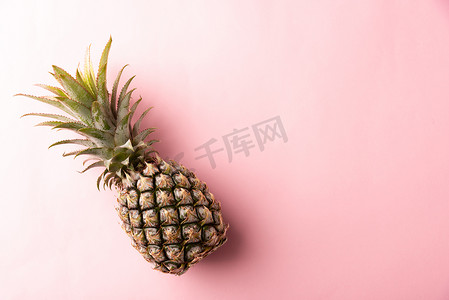 粉红色柔和背景中成熟的菠萝果实