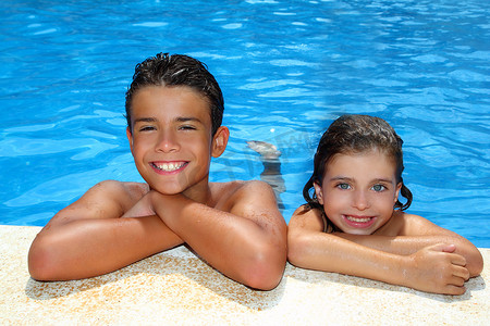暑假游泳摄影照片_少年男孩和小女孩在蓝色游泳池暑假