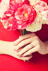 女人手上拿着鲜花和戒指