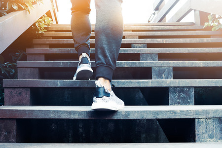 一个人迈向成功，运动员在木台阶上攀登