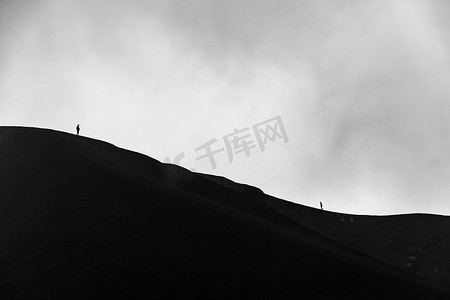 攀登在埃特纳火山火山口边缘的人的小剪影