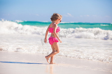 走在墨西哥白色沙滩上的可爱小女孩