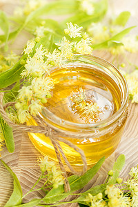 玻璃罐中的蜂蜜，开着白色的椴树花