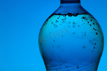矿泉水瓶摄影照片_蓝色背景中的矿泉水瓶