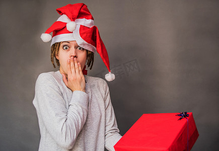戴着树圣诞帽、留着爆炸头的女人看着当下，感到惊讶