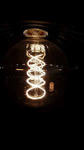 深色背景中带有文本空间的经典爱迪生灯泡的垂直照片