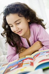 客厅里的小女孩看书微笑（高调/选择性焦点）