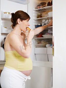 孕妇饮食摄影照片_吃三明治的孕妇