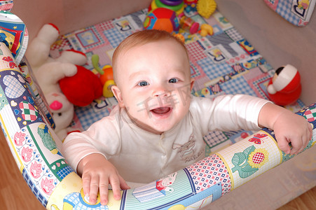 “微笑的孩子在婴儿床上玩耍，家庭场景”