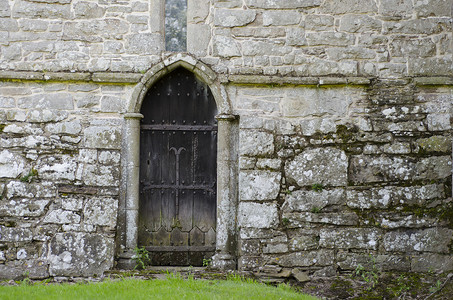 “一扇古老的木门，位于 14 世纪古老教堂的石墙上”