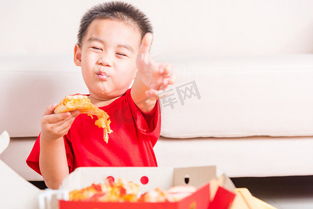 小孩吃手指摄影照片_小孩吃外卖比萨饼并展示好手指拇指