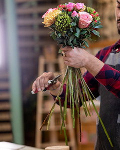 企业喜庆摄影照片_卖花人做花束，在店里切花