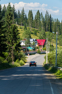 林区摄影照片_林区的一条路通往一座彩色屋顶的小屋