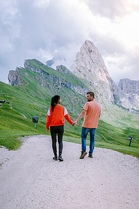 一对夫妇在 Italien Dolomites 度假远足，在 Seceda 峰上欣赏美景。