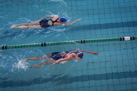 女游泳运动员在游泳池里赛跑