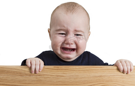 哭泣摄影照片_拿着木板的哭泣的幼儿