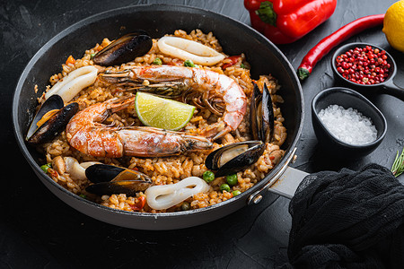 海鲜饭传统西班牙菜在煎锅中供应，黑色纹理表面