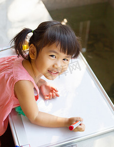 可爱的孩子在上课前练习在白布上写字