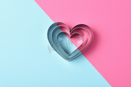 嵌套摄影照片_情人节概念：粉红色和蓝色的嵌套心形饼干切割器，带有复制空间。