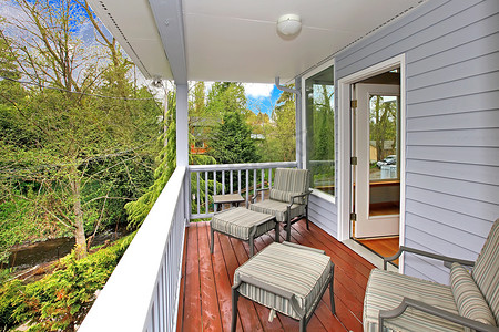 带户外家具的阳台，可欣赏树林和河流景观。