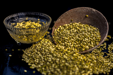 绿豆或 moong dal 在粘土碗中的特写镜头，以及一些水和 moong dal 在黑色光滑的表面上充分混合。