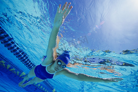 游泳比赛中的中年女性参赛者在水下游泳