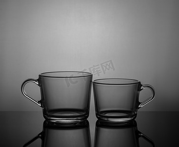 器皿摄影照片_深色背景中带背光的空茶杯