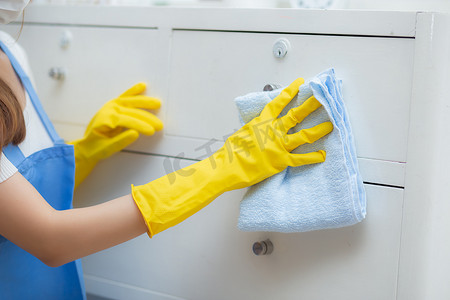 亚洲年轻女性戴着手套在房间里打扫房间的特写手，管家用织物擦拭，女佣和服务，工人在家里打磨灰尘，家务和家务，生活方式概念。