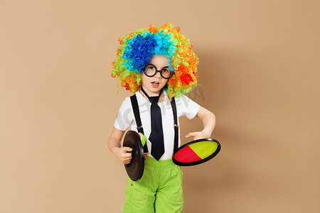 戴着小丑假发和眼镜玩接球游戏的孩子