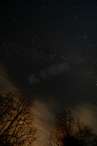 星星云朵背景摄影照片_布满星星和橙色云朵的夜空