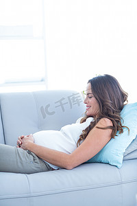 照顾孕妇摄影照片_在家放松的微笑的孕妇