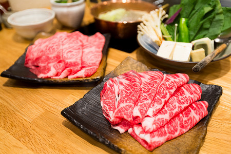 寿喜锅摄影照片_涮涮锅和寿喜烧的新鲜牛肉和猪肉片
