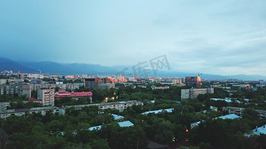 哈萨克斯坦地标摄影照片_日落时分山和阿拉木图市上空的云
