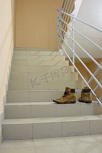 废弃楼梯摄影照片_楼梯上有废弃的靴子