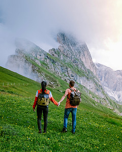 一对夫妇在 Italien Dolomites 度假远足，在 Seceda 峰上欣赏美景。