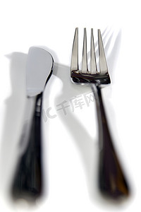 就餐礼仪摄影照片_有阴影的银色叉子和刀子